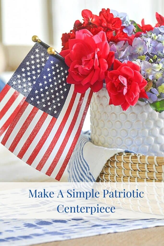 red, white and blue patriotic centerpiece in a basket with two small American flags