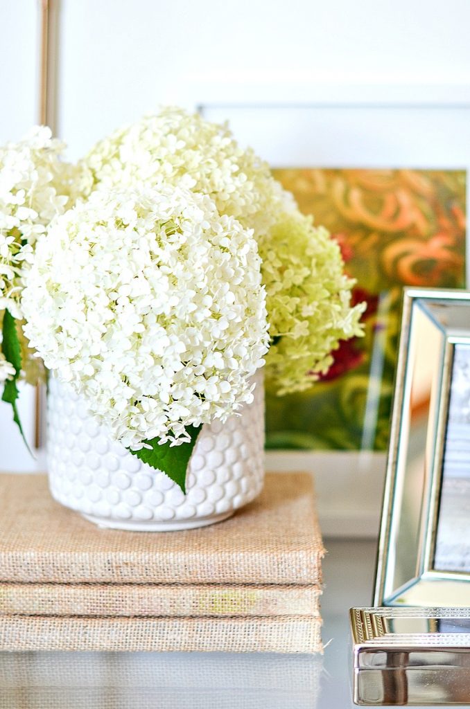 cut hydrangeas in a vase on a round nightstand
