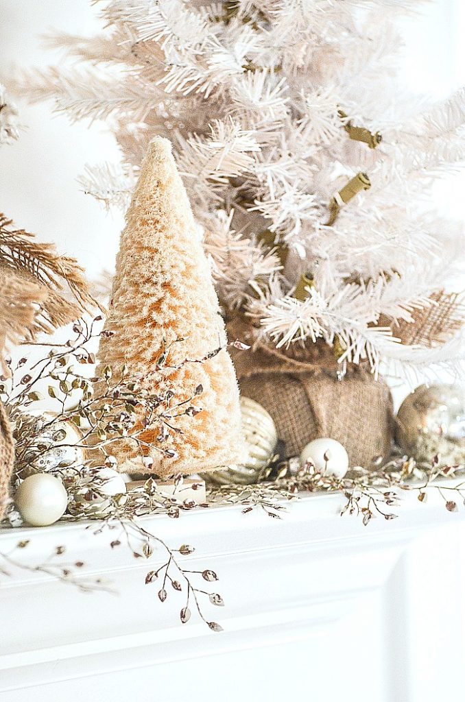 white bottle brush trees and small ornaments on a Christmas mantel