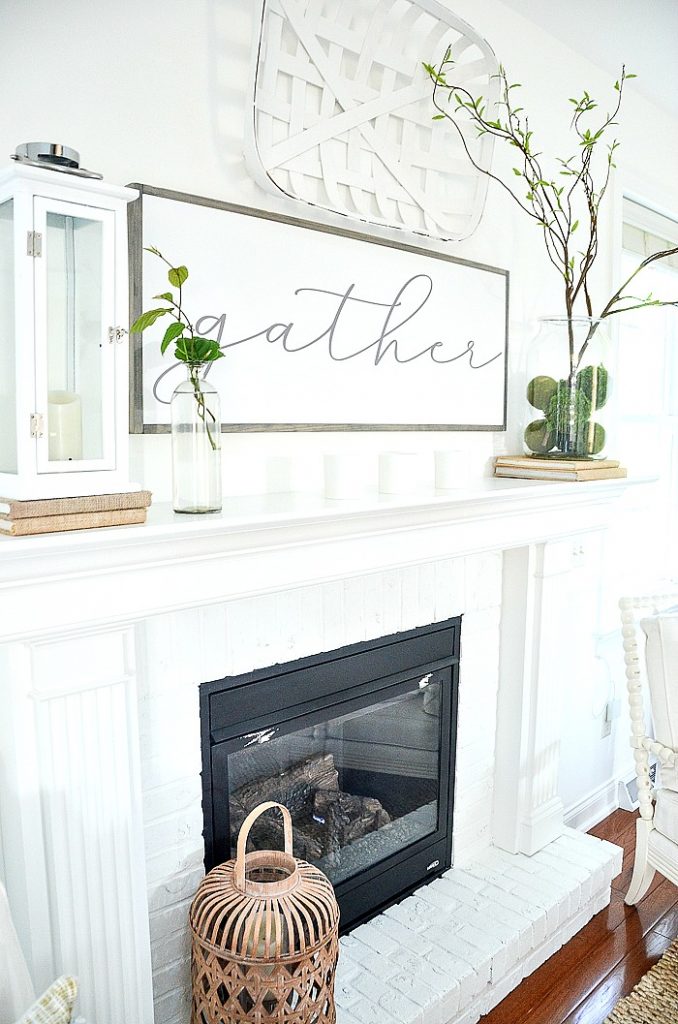 a white fireplace with a big sign that says "gather"