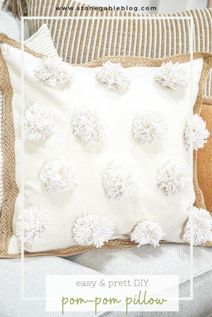 Trio of pillow on a sofa- featured pillow has pom-poms on the front of it