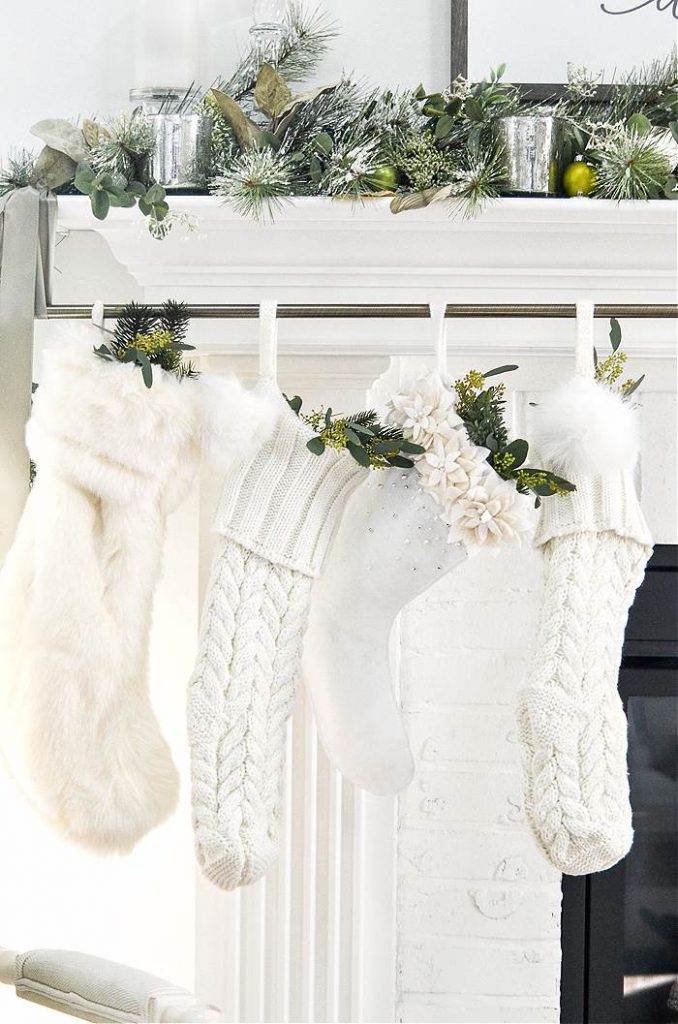 4 WHITE STOCKINGS HANGING ON A MANTEL