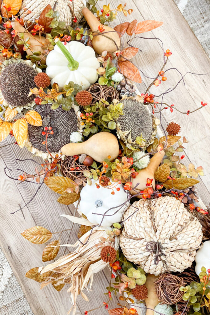 adding snippets of faux greens to a fall dough bowl