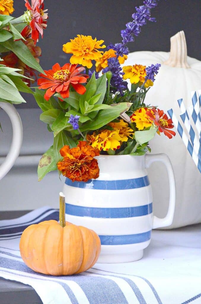 orange pumpkin and a pitcher of garden flowers