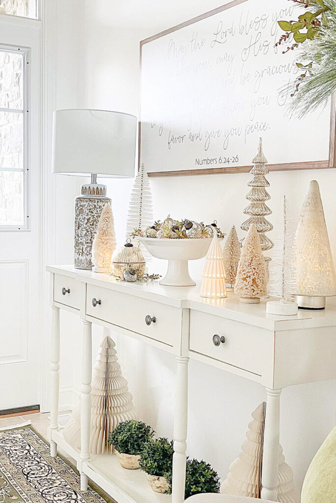 A FOYER CONSOLE WITH WHITE TREES ON IT