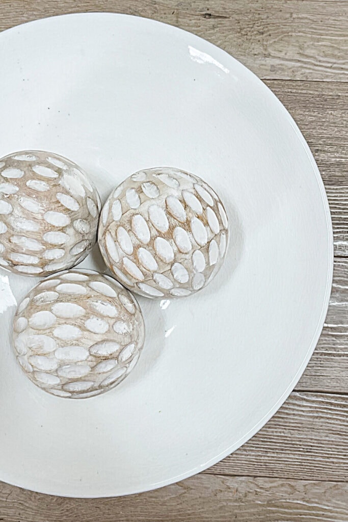 white washed wooden balls in a white bowl