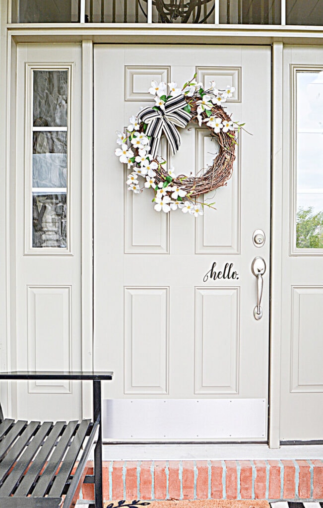 FRONT DOOR WITH DOGWOOD WREATH ON IT
