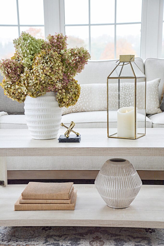 SMALL SPACES- WHITE VASE OF HYDRANGEAS ON A COFFEE TABLE