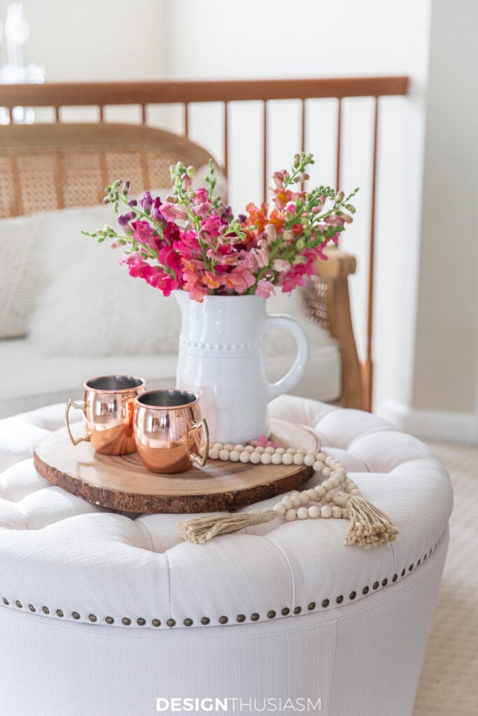 FLOWERS ON AN UPHOLSTERED COFFEE TABLE