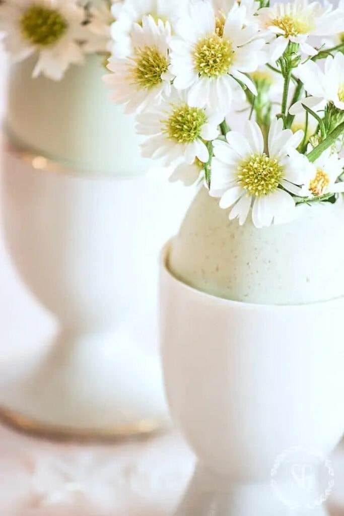 tiny flowers in eggshells vases.