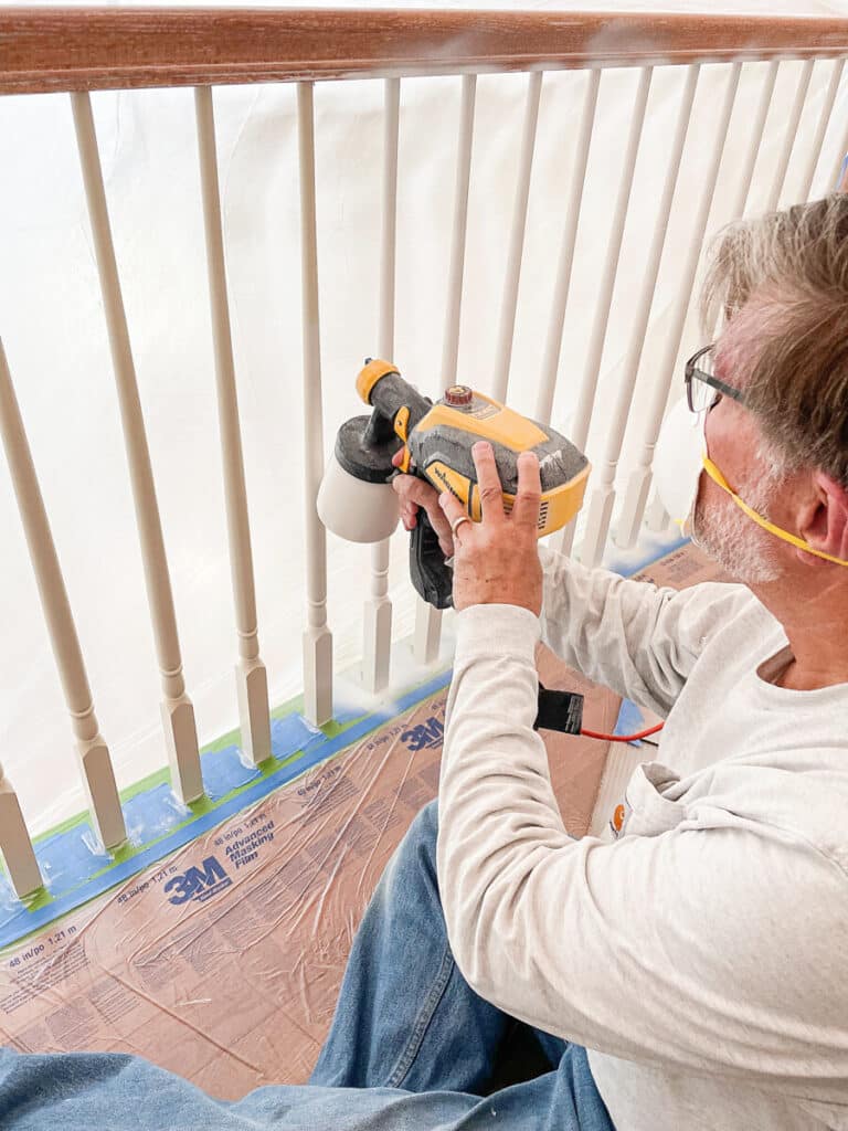 spraying the spindles on the stairs with a low pressure paint sprayer