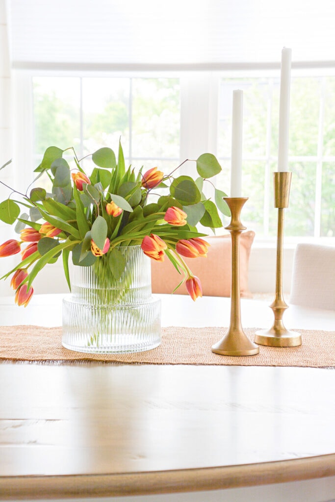 small dining room - tulips and brass candlesticks on a dining table