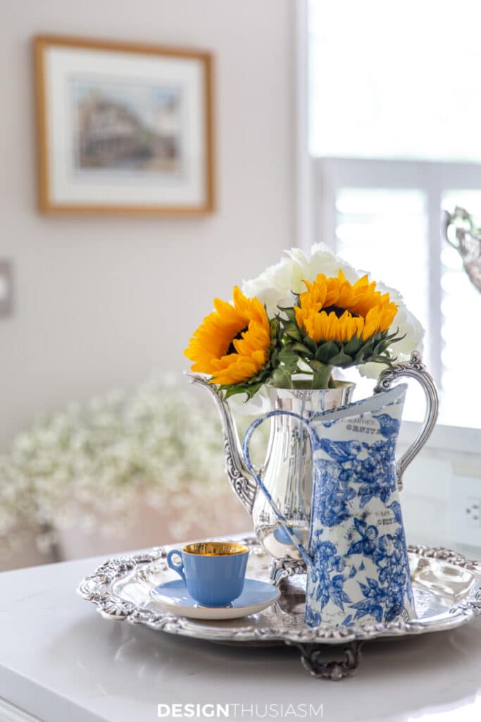 sunflowers in a pitcher on a silver tray
