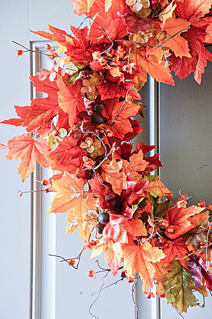 Close up of a Wreath with lots of colorful leaves on it.