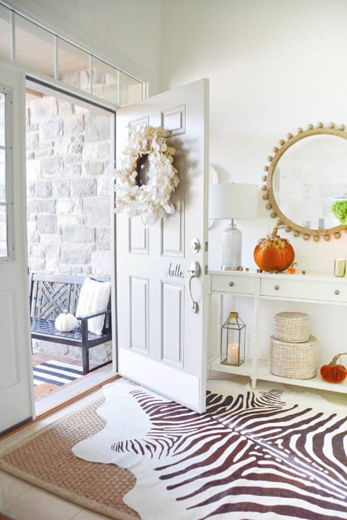 a fall front door open to a decorated foyer