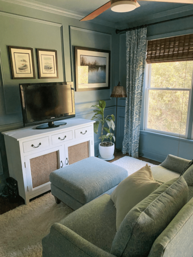 a family room featuring a painted hutch with a tv on it