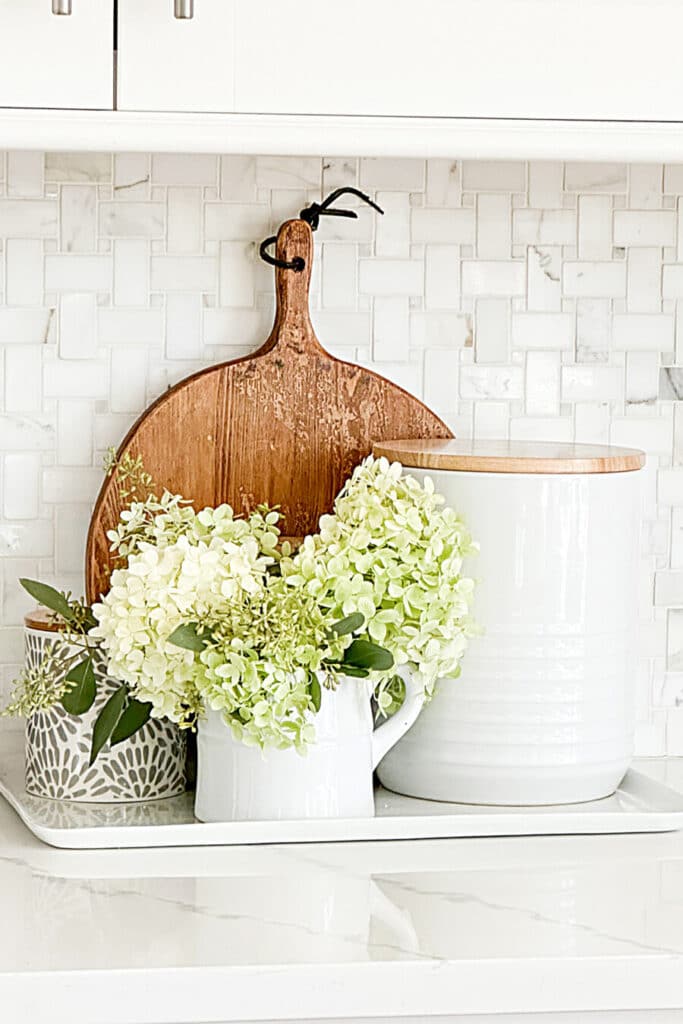 containers with wooden lids and hydrangeas in a pitcher