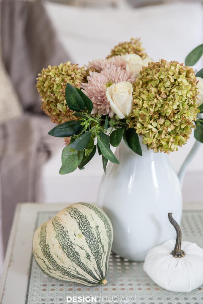 flowers in a vase and pumpkins