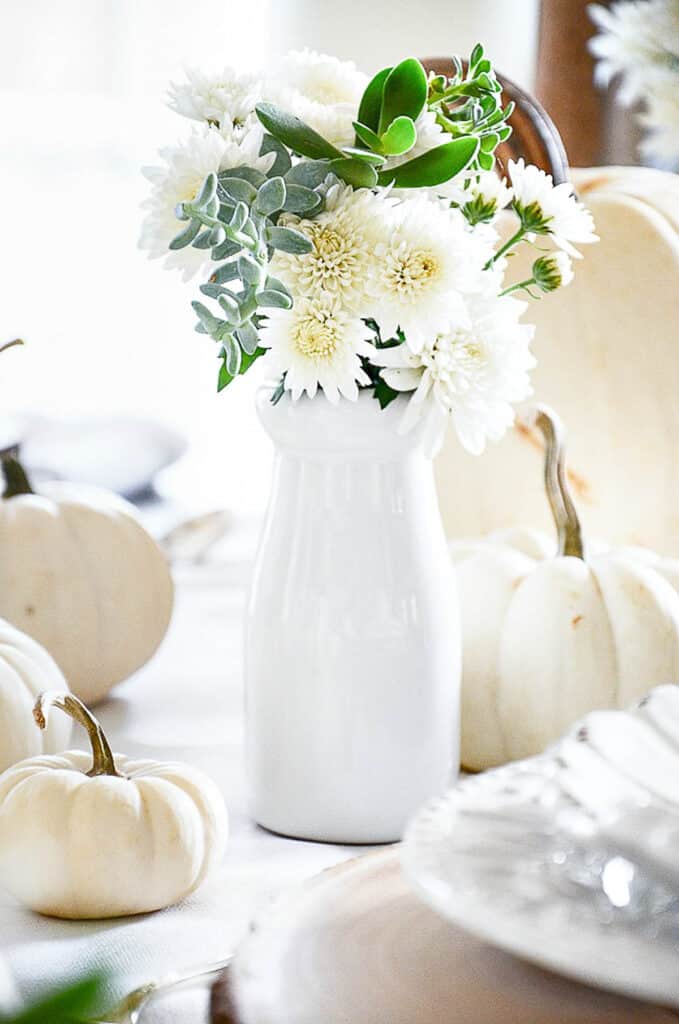 WHITE MUMS IN A WHITE VASE ON A THANKSGIVING TABLE