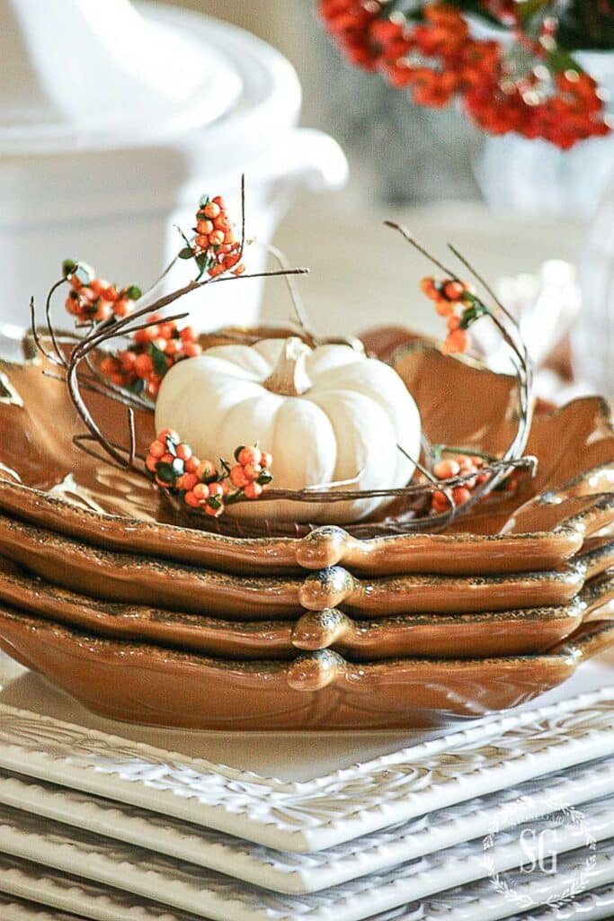 stack of leaf plates with a white pumpkin on top