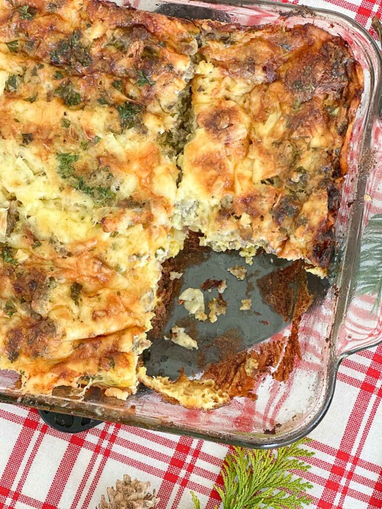 CHRISTMAS BREAKFAST CASSEROLE- casserole with one pecie cut out