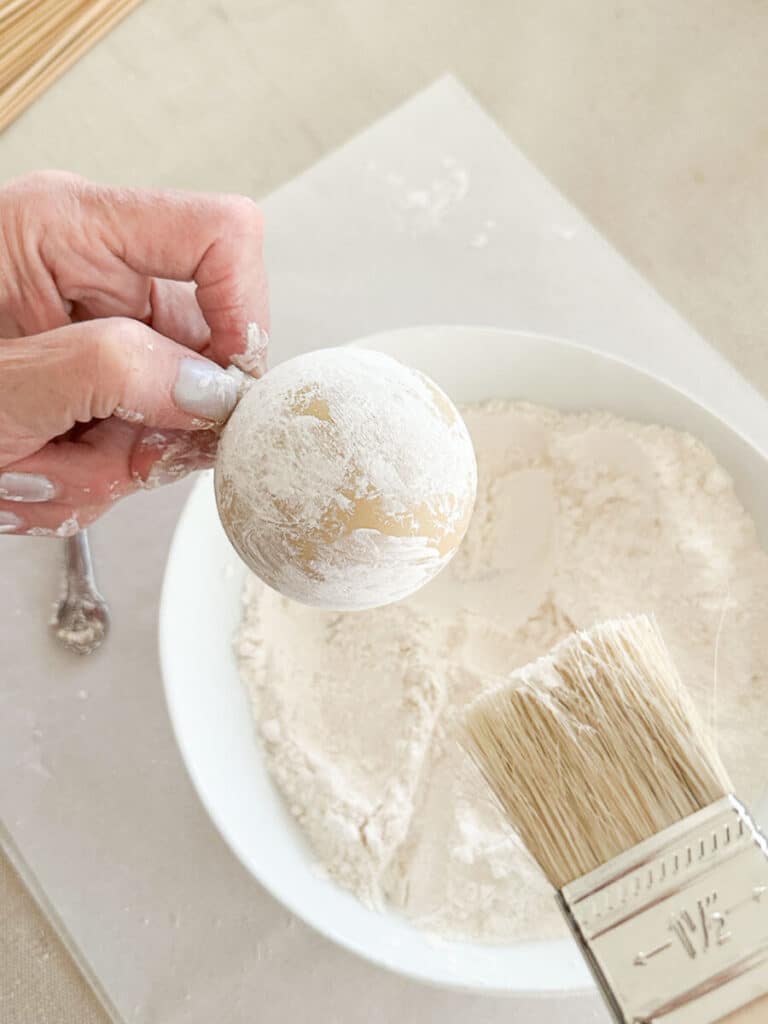 brushing off flour from the ornament