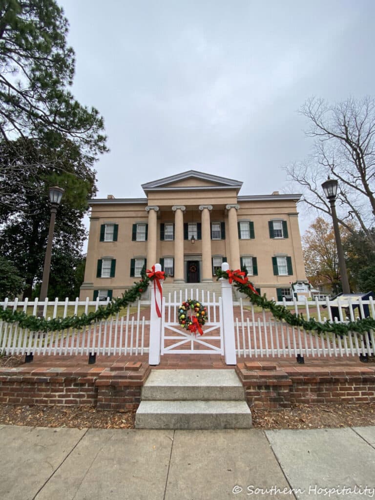 mansion with garland and a wreath on a gate