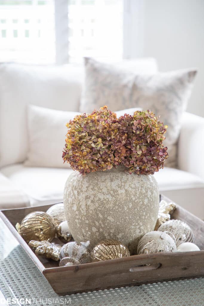 stone vase with dried hydrangeas and Christmas ornaments