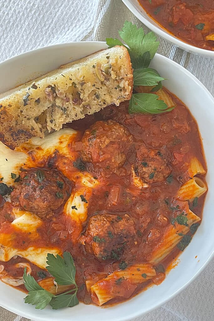 rigatoni soup with meatballs and garlic bread in a bowl