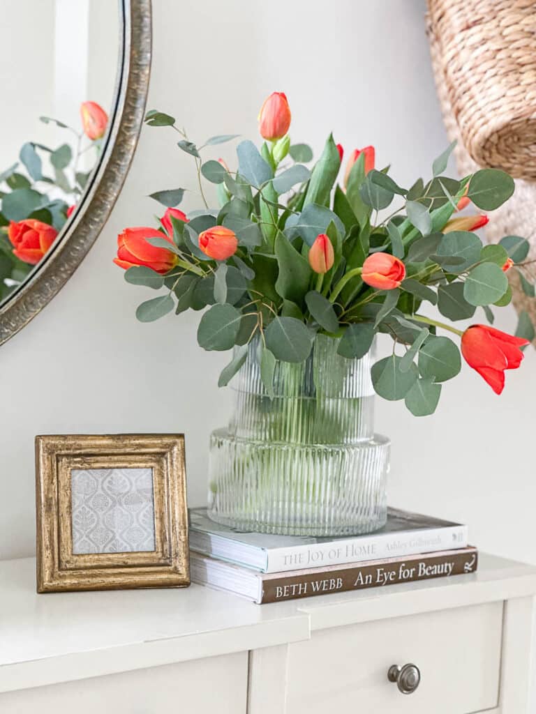 1 FOYER TABLE DECOR- orange tulips on a stack of decorating books