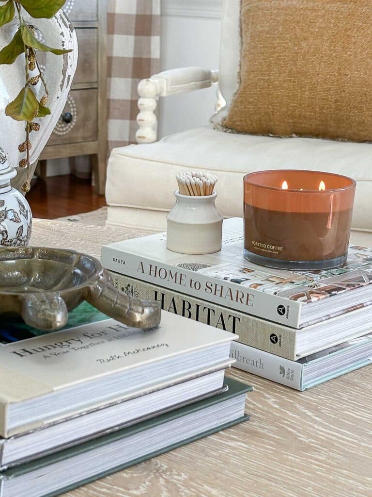 Decorating A Coffee Table- close up of a candle and little container of matches on a stack of books