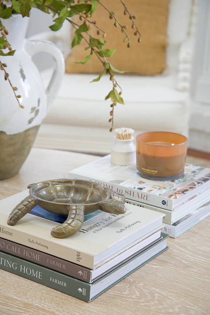Decorating A Coffee Table- a turtle bowl and a candle on two stacks of books