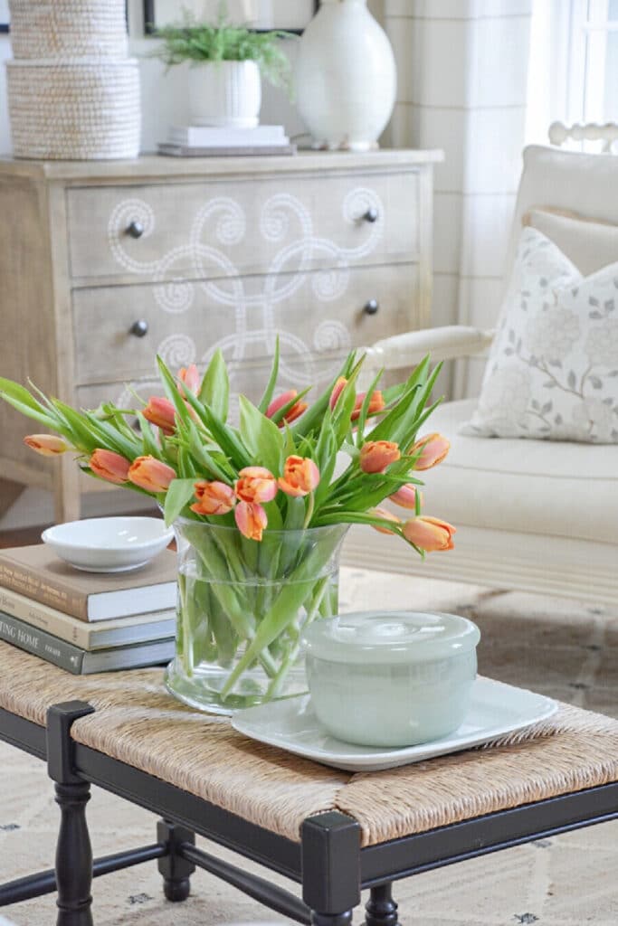 orange tulips on a bench with books