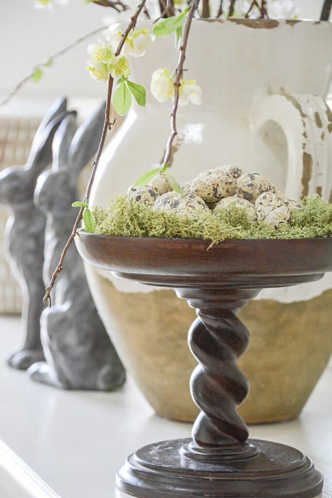tiny faux eggs on a pedestal filled with moss- spring decor