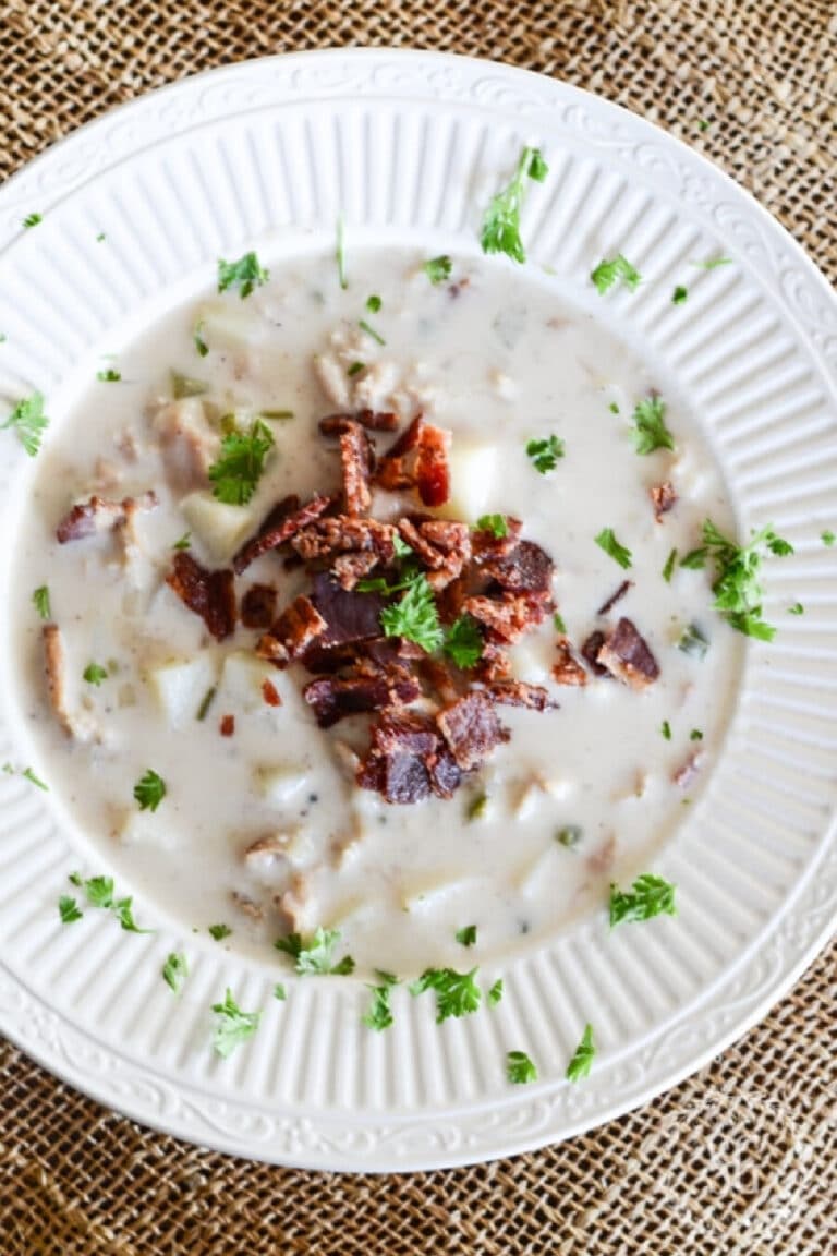 a bowl of clam chowder with bacon bits on the top