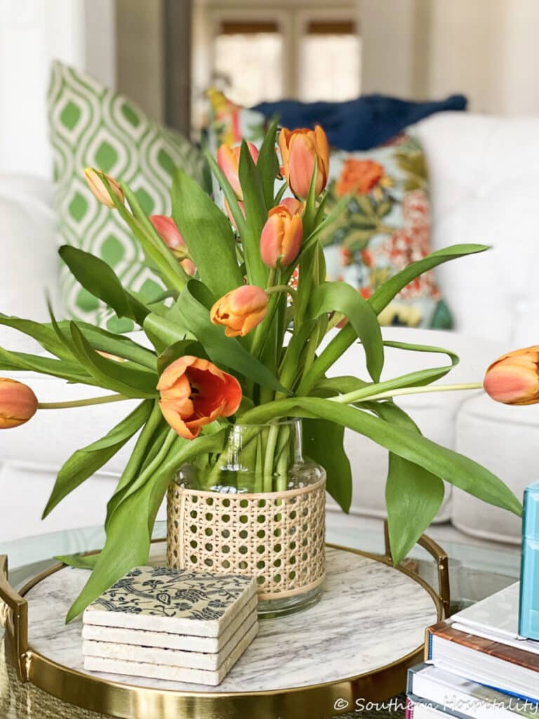 tulips arranged in a glass and wicker vase
